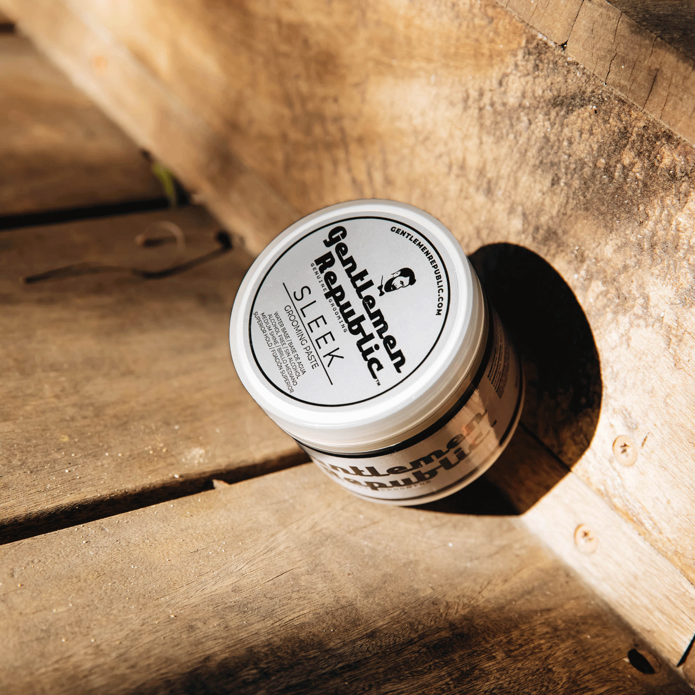 Sleek Grooming Paste jar on wooden steps